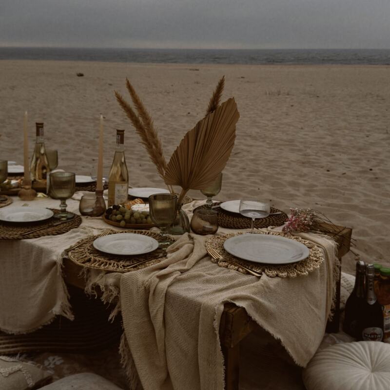 Boho beach dinner table with pampas and cushions