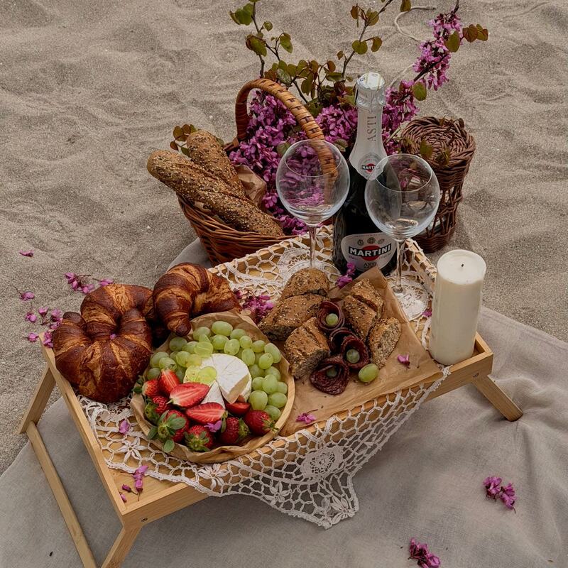 Picnic tray with croissants, fruit and sparkling wine